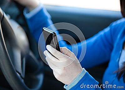 Close-up of a teenager sending a text in her car Stock Photo