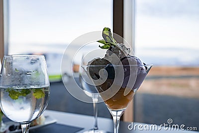 Close-up of tempting dessert and wineglass on table against window at hotel Stock Photo