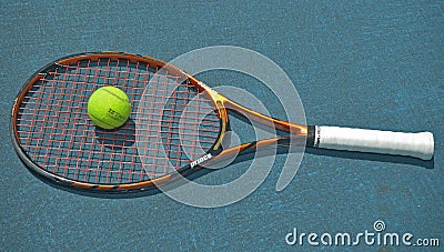 Close up of a tennis racket and a ball resting on the surface of a tennis court Editorial Stock Photo