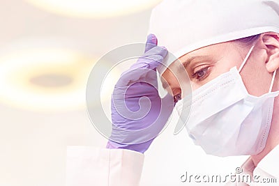 Close-up of tensed dentist wearing surgical gloves and mask Stock Photo