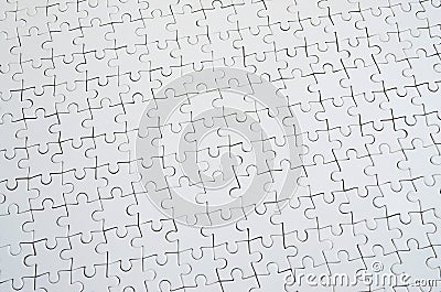 Close up texture of a white jigsaw puzzle in assembled condition. Top view. Many components of a large whole mosaic are united Stock Photo