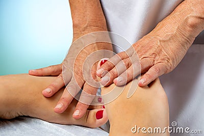 Physiotherapist manipulating female feet with hands. Stock Photo