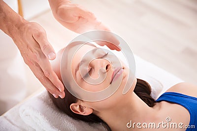 Therapist Performing Reiki Healing Treatment On Woman Stock Photo
