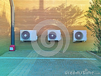 Close-up of three air conditioner outdoor units. Three air conditioners fixed on the wall of the building Stock Photo