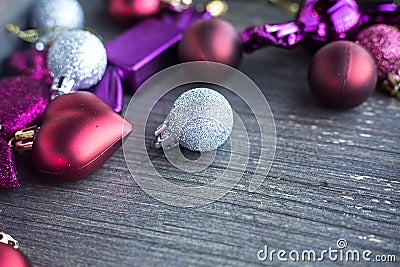 Close up of tiny silver sparkling Christmas ball. New year toys, hearts and balls on wooden grey surface. Flat layer Stock Photo