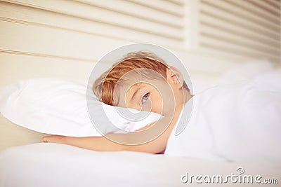 Close up of tired boy in bed. Stock Photo