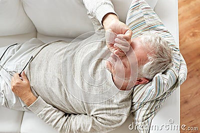 Close up of tired senior man lying on sofa at home Stock Photo