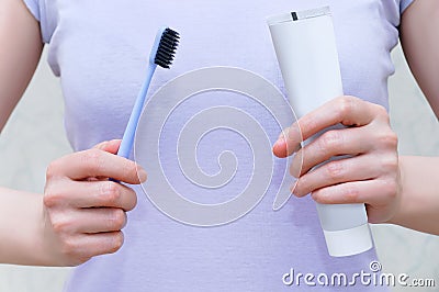 Close-up of a toothbrush and paste in the hands of Caucasian woman Stock Photo