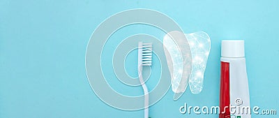 Close up of a toothbrush and toothpaste with thin linear Low poly tooth icon on blurred blue background. Means to care for the Stock Photo