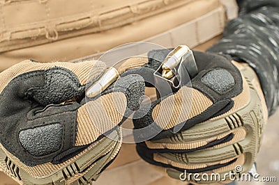 View of soldier hands load gun bullets into cartridge clip Stock Photo