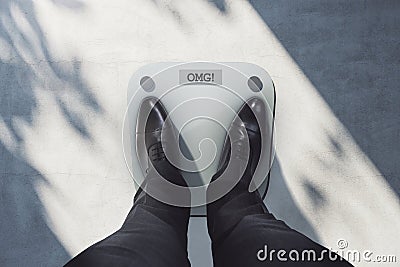 Close up and top view of business man feet on scales asking for help. Lose weight concept Stock Photo