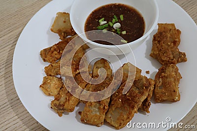 Close-up, top view, pork belly marinated in fish sauce, battered and fried with sauce placed on a plate. Stock Photo