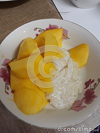 Close-up, top view, steamed sticky rice with sugar and coconut milk with ripe mango, Thai dessert concept. Stock Photo