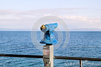 Close-Up of tourist telescope on strand beach at sandy mount / Sightseeing telescope with the view of Mediterranean. Stock Photo