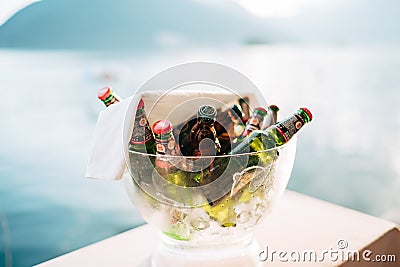 Perast, Montenegro - 03 august 2020: A close-up of a transparent ice jar with full bottles of light and dark beer and Editorial Stock Photo