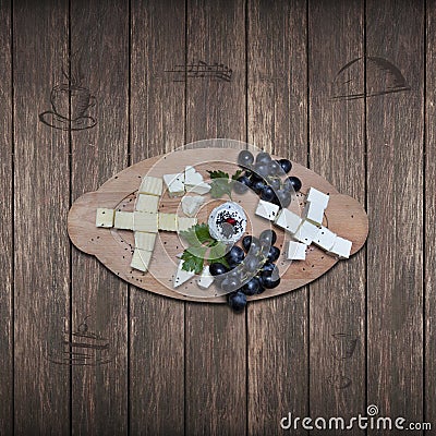 Close up of a tray of assorted rustic bread and cheese with olives and grapes. Stock Photo