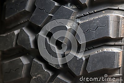 Close-up on the black tire for an SUV with a rough pattern on rubber. Brutality, rudeness and stiffness of men Stock Photo