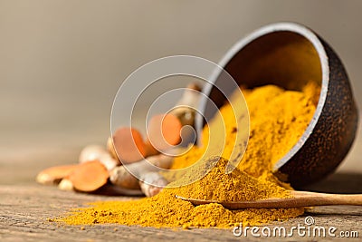 Close-up of Turmeric powder in wooden spoon Stock Photo