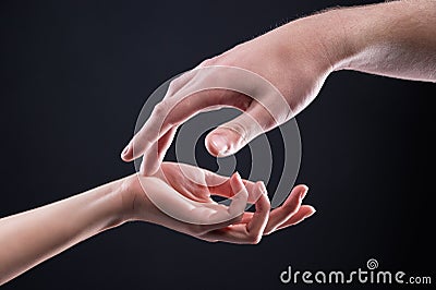 Close-up two beautiful hands of a man and a woman in a gentle gesture of touch. The concept of tenderness of touch and Stock Photo