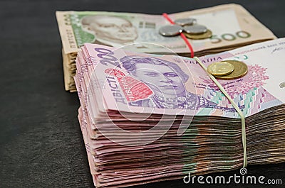 Close-up of two bundles of hryvnia and coins. Financial concept. Ukrainian banknotes of 500 and 200 hryvnia. Lots of banknotes. Mo Stock Photo