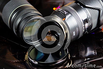 Close up of two camera lenses with isolated circular filter on negative film strips Stock Photo