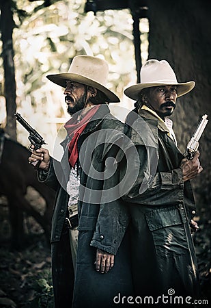 Close up Two cowboys standing and holding short gun Stock Photo