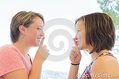 Close up of Two Cute Girls Asking for Silence Stock Photo