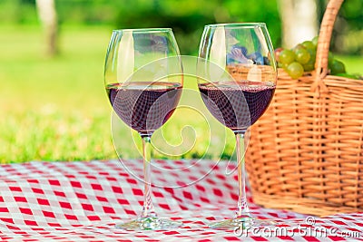 close-up two glasses of wine on a picnic, on a checkered tablecloth on a lawn Stock Photo