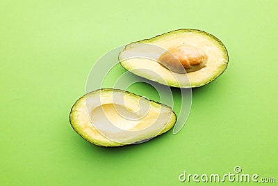 Close up of two halves of avocado and copy space on green background Stock Photo