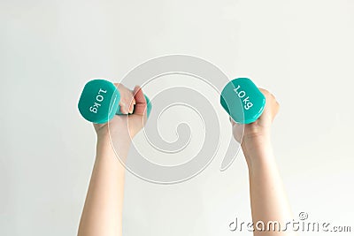 Close-up image of two hands lifting dumbbells overhead on white background Stock Photo