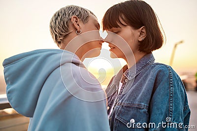 Close up of two passionate women kissing outdoors, Young lesbian couple enjoying romantic moments together at sunrise Stock Photo