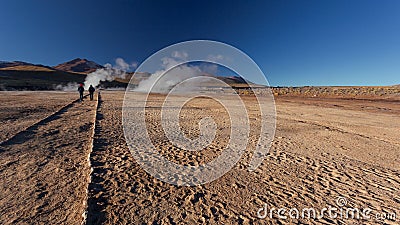 Close up of two persons following path. Taken during the sunrise at Geysers of Tatio at Los Flamencos national reserve in Atacama Stock Photo