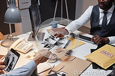 Close up of two police detectives handing pictures of evidence Stock Photo