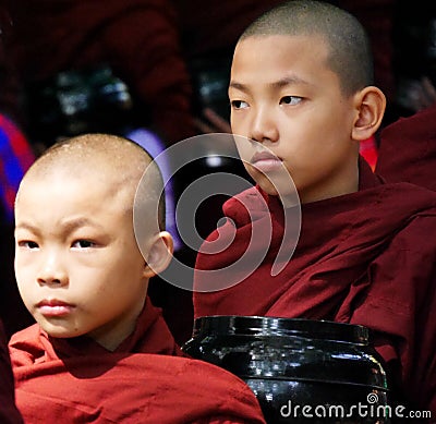 Close up of two serious young Buddhist novices in maroon robes,Myanmar Editorial Stock Photo