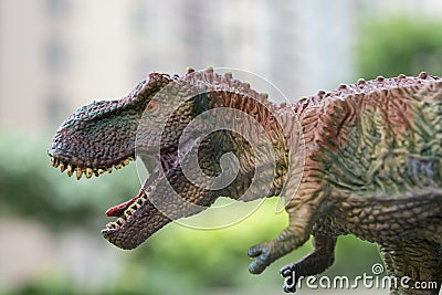 Close up tyrannosaurus toys head with building at back Stock Photo