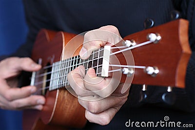 Close up ukulele in musician hands, left hand view Stock Photo