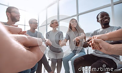 Close up. United team of young people sitting in a circle Stock Photo