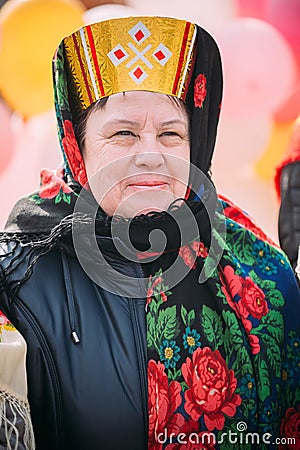 Close up of unknown beautiful aged woman in national folk clothes at Celebration of Maslenitsa Shrovetide holiday Editorial Stock Photo