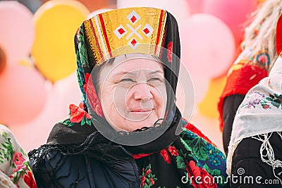Close up of unknown beautiful aged woman in national folk clothes at Celebration of Maslenitsa Shrovetide holiday in Editorial Stock Photo