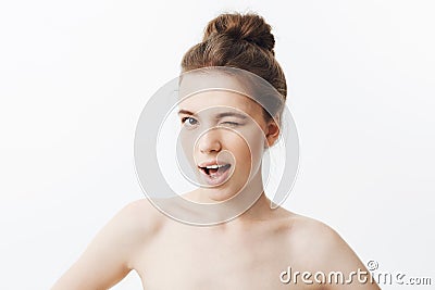 Close up of unny young girl with brown long hair in bun hairstyle and skinny body type, being half naked, holding hands Stock Photo