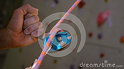 CLOSE UP: Unrecognizable belayer helps a climber descend after climbing a wall Stock Photo