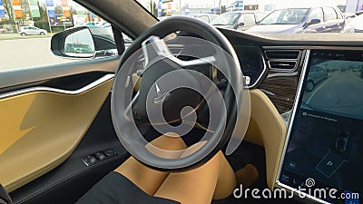 CLOSE UP: Unrecognizable businesswoman sits in high tech self parking Tesla car. Editorial Stock Photo