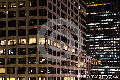 Close up urban scene of modern buildings at night with colorful glowing windows, lights and reflections Stock Photo