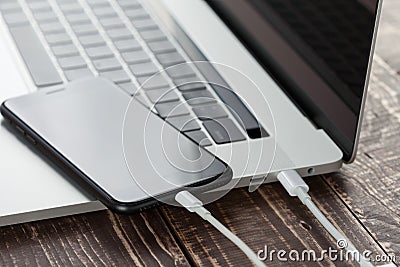 close-up usb cable connect phone and laptop computer new technology concept Stock Photo