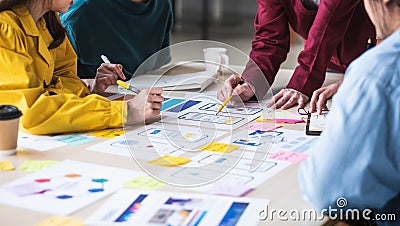 Close up ux developer and ui designer brainstorming about mobile app interface wireframe design on table with customer brief and Stock Photo