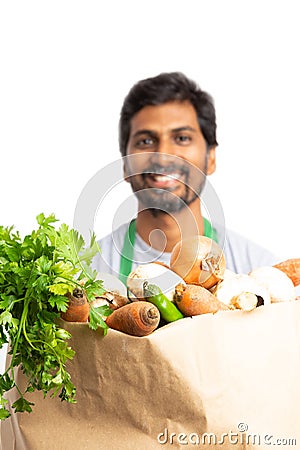 Close-up of vegetable bag held by grocery store employee Stock Photo