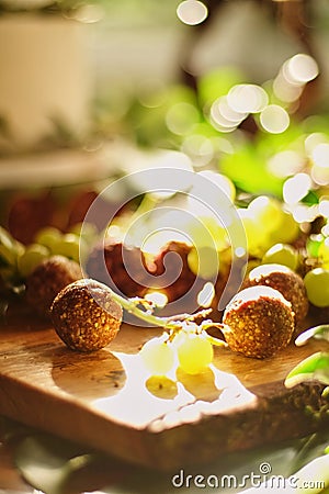 close-up, vegetarian coconut candies, with grapes, on a table with a sunbeam Stock Photo