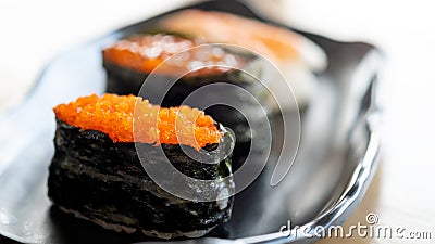 Close up Vibrant Tobiko Gunkan Sushi Focus on a Ceramic Plate Stock Photo