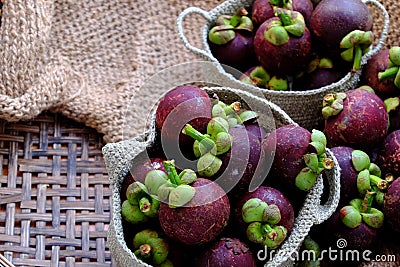 Close up fresh Mangosteens fruit in handbag on burlap background Stock Photo