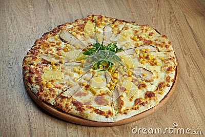 Close up view on Appetizing Hawaiian pizza with melted cheese, chicken and pineapple on wooden background Italian cuisine Stock Photo